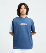 Remera de corte relajado color azul, con cuello redondo y mangas cortas. Presenta paneles laterales en color blanco con ribetes negros y un estampado frontal con el texto 'openminds' en un diseño ovalado.