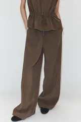 Pantalón negro de tiro medio, con cintura elástica y cordón ajustable. Tiene bolsillos delanteros y bajo ajustable con cordones del mismo tejido.