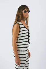 Chaleco tejido a rayas horizontales blancas y negras, con lazos delanteros.