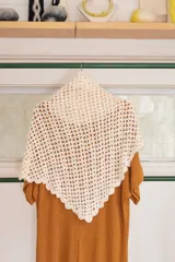 Chal triangular tejido a mano con la técnica de crochet, color crudo.