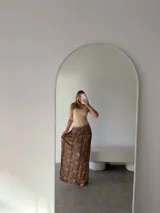 Pollera larga de corte recto con estampado animal print en tonos marrones y negros. Confeccionada en una mezcla de algodón y viscosa, presenta una caída fluida y elegante.