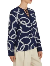 Blusa vaporosa Tommy Hilfiger de color azul marino con estampado integral de cuerdas blancas de estilo marinero. Presenta cuello en V con cordones para anudar, mangas largas con puños abotonados y corte regular.