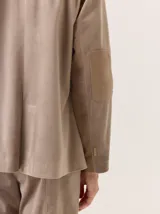 Blazer negro de simil terciopelo con cuello y puños en color marrón. Tiene bolsillos delanteros y forro estampado.