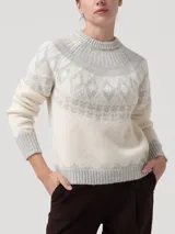 Sweater de punto con diseño jacquard circular en el yugo, mangas y ruedo. Presenta cuello redondo, mangas largas y puños acanalados en un tono beige claro con detalles en gris.