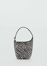 Bolso tipo bucket con estampado cebra, asa corta, cierre de botón magnético, detalle metálico y forro interior.