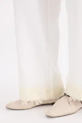 Pantalon tejido de corte recto y tiro alto, color blanco, con detalle de encaje y perlas en el ruedo.