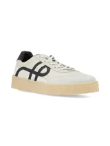 Championes urbanos de color blanco off-white con detalles en negro y suela de goma texturizada en tono tostado. Presentan diseño lateral con líneas curvas en contraste y puntera de gamuza.