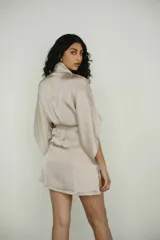 Bata color crema confeccionada en seda, con lazo de ajuste en la cintura.