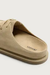 Zueco de hombre fabricado en piel con acabado de serraje. Presenta un diseño de parte superior lisa con detalle de costura en el empeine, horma redonda y suela a contraste.