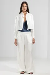 Pantalón de lino italiano color blanco con hilo metalizado, corte recto, talle medio, cintura elástica en la parte trasera y bolsillos delanteros.