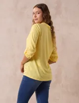 Blusa amarilla de manga 3/4 con escote en V y bordado multicolor. Largo de manga regulable con presilla y botón. Marca Ruby Rd.