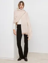 Bufandón tejido de poliéster, color rosa pálido con textura jaspeada en tonos pastel (naranja, lila, gris). Presenta un tejido grueso y flecos en los bordes.