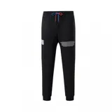 Pantalón de jogging negro con puños elásticos, cintura ajustable con cordón y estampado con logos de la NBA y nombres de equipos.