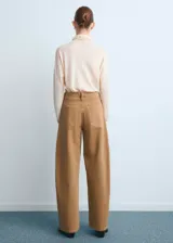 Jeans de corte wide leg y tiro medio en color tostado, con diseño de perneras abuchonadas y bolsillos delanteros simulados.