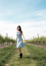 Vestido corto celeste con breteles finos, espalda descubierta con detalle de encaje y volados en el ruedo.