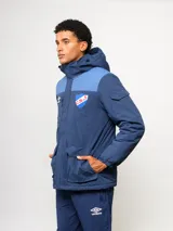 Parka de abrigo Umbro del Club Nacional de Football, con diseño de bloques de color en azul, rojo y blanco. Cuenta con capucha, cierre frontal, bolsillos frontales y el escudo del club bordado en el pecho.