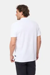 Remera polo de piqué color blanco, con cuello y puños en rib, cierre frontal con botones y logo bordado pequeño en el pecho.