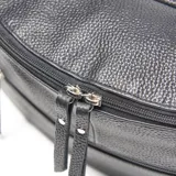 Riñonera de cuero color negro, con forma curva y textura granulada. Posee dos compartimentos frontales con cierre y un bolsillo interno con cierre. Incluye correa ajustable para llevar al hombro o cruzada.