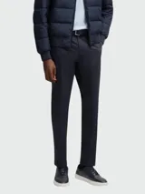 Pantalones de vestir de corte recto y diseño clásico, confeccionados en tejido liso de color azul oscuro. Presentan cierre frontal con cremallera y botón, trabillas para cinturón y bolsillos laterales.