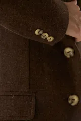 Blazer largo color crema con cuello solapa, bolsillos con solapa y forro interior combinado a tono. Confeccionado en lana fina sin teñir.