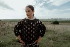 Buzo de tejido calado con diseño de red, color marrón oscuro, de corte holgado y manga larga.