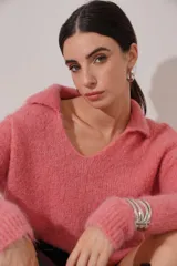 Buzo de tejido de punto peludo color rosa fuerte, con cuello polo y escote en V.