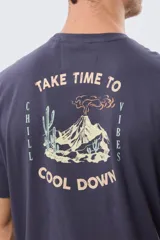 Remera gris oscuro de manga corta y cuello redondo, con un estampado gráfico en la espalda que incluye un paisaje de montaña y la leyenda "Take time to chill vibes cool down".