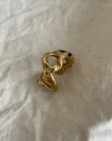 Anillo de bronce con diseño orgánico y aberturas irregulares.