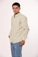 Camisa de manga larga en color gris, confeccionada en algodón, con cuello abotonado y cierre frontal de botones.