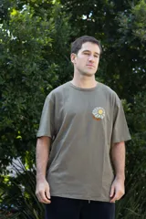 Remera color beige de manga corta con estampado de un sol en el pecho. Corte clásico y cuello redondo.