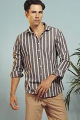 Camisa de manga larga en color salmón con estampado de pequeños motivos geométricos oscuros, cuello clásico y cierre frontal con botones.