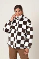 Campera de textura tipo peluche con diseño de cuadros damero en color marrón y blanco. Presenta cuello alto, cierre frontal completo y bolsillos laterales.