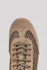 Championes de gamuza color tostado con diseño de paneles perforados en los laterales y empeine. Presentan cierre con cordones al tono y tirador en el talón.