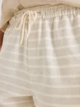 Bermuda de tela texturizada con diseño de rayas horizontales en color beige y blanco, con cintura elástica y cordón ajustable.