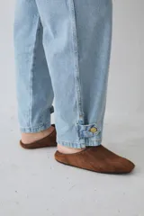 Pantalón tipo bombacha de campo confeccionado en denim azul. Presenta pinzas frontales, cierre de botones en los tobillos para ajustar la silueta y costuras reforzadas.
