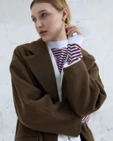 Par de aros colgantes de bronce y alpaca color plateado, con forma orgánica irregular y textura martillada. Cierre con perno y mariposa de plata 925.