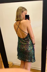 Vestido corto de lentejuelas tornasoladas con espalda baja y tirantes finos cruzados.