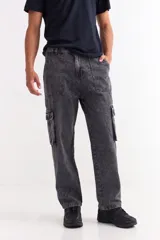 Pantalón tipo jean de corte baggy con diseño cargo, presenta bolsillos laterales amplios con solapa y costuras reforzadas. Confeccionado en denim de algodón con acabado lavado.