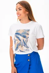 Remera blanca de algodón con estampado de plumas en tonos azules y beige.
