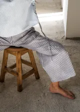 Pijama de algodón a rayas, compuesto por una remera de manga corta con cordones ajustables en los laterales y un pantalón de corte recto y holgado.