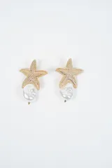 Aros colgantes con diseño de estrella de mar texturizada en tono dorado, con una perla barroca irregular colgando de la parte inferior.