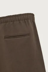 Pantalón jogger de corte regular fit y color negro, confeccionado en tejido compacto de algodón con interior de rizo. Cuenta con cintura elástica, bolsillos frontales y un bolsillo trasero de doble vivo.