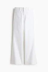 Pantalón jean de denim color blanco, de tiro alto y corte acampanado desde la rodilla. Cuenta con bolsillos parche delanteros y traseros, cierre frontal con botón metálico y trabillas para cinturón.