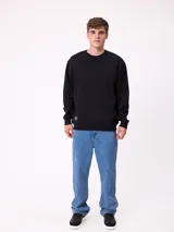 Jean de corte slouchy fit, confeccionado en denim de algodón color azul medio. Presenta diseño de cinco bolsillos, cierre frontal con botón y costuras reforzadas en tono contrastante.