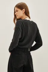 Cardigan crop negro tejido en punto desagujado con lurex, escote V cruzado y lazo de ajuste en la cintura.