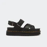 Sandalias Dr. Martens modelo Voss II, color negro, con tiras cruzadas en el empeine, correas ajustables con hebilla en el talón y tobillo, suela flatform dentada de EVA con el inconfundible pespunte amarillo de la marca.