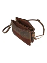 Cartera tipo bandolera de diseño rectangular, confeccionada en una combinación de cuero liso en la parte superior y cuero con pelo en la parte inferior, unidos por costuras decorativas visibles. Cuenta con correa ajustable y extraíble, cierre superior de cremallera y herrajes metálicos en tono bronce envejecido.