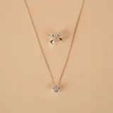 Set de joyería compuesto por collar con dije de punto de luz y par de caravanas a juego, confeccionados en plata 925 con engaste de circonias.