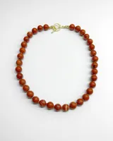 Collar corto de cuentas esféricas de piedra jaspe rojo con vetas claras, con cierre marinero dorado.