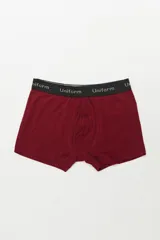 Boxer de algodón color vino tinto con elástico negro que lleva la palabra "Uniform" repetida en blanco.